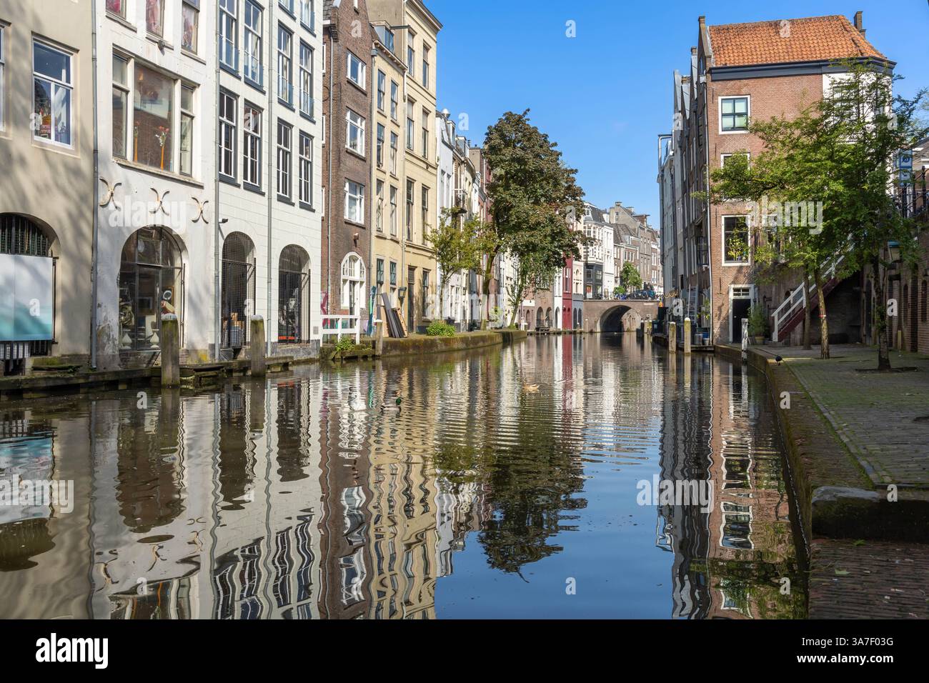 Traditionelle Kanalhäuser aus Ziegelstein, eine Werft mit Holztreppen auf der anderen Seite der Häuser und im Abstand eine Brücke in Utrecht Stockfoto