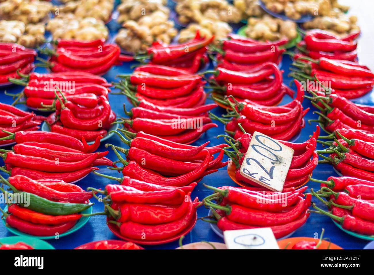 Ein lebhafter Haufen frischer roter Chilischoten, die auf einem geschäftigen Markt in Kuching, Malaysia, zum Verkauf angeboten werden Stockfoto Ein lebhafter Haufen frischer roter Chilischoten, die auf einem geschäftigen Markt in Kuching, Malaysia, zum Verkauf angeboten werden Stockfoto