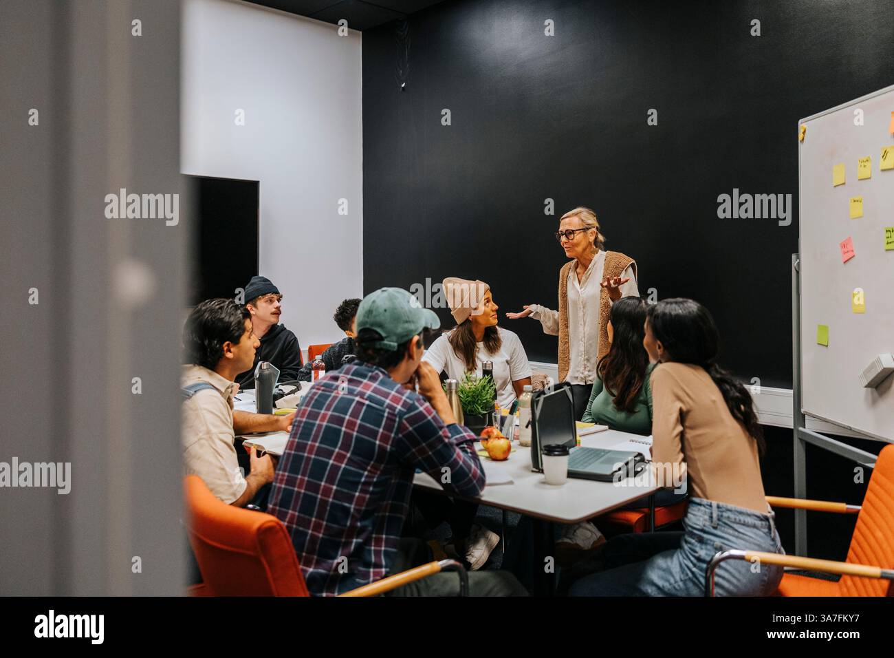Reife Lehrerin, die multirassische Studenten im Klassenzimmer unterrichtet Stockfoto