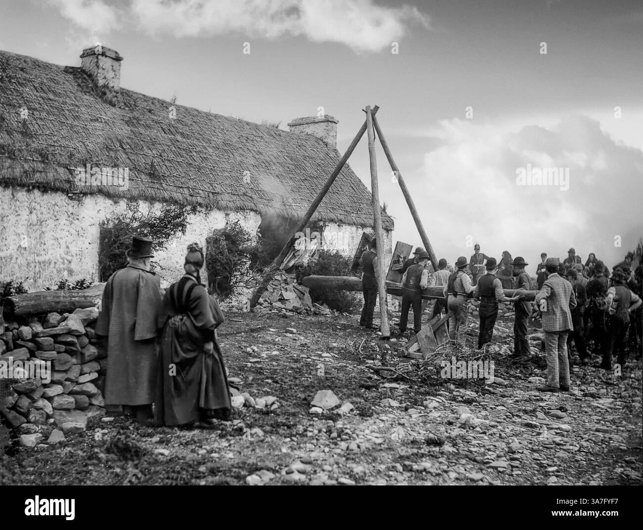 Eine Vintage-Fotografie von der Vertreibung einer irischen Familie im Jahr 1888 in Moyasta, County Clare, bei der ein Rammbock verwendet wurde. Die meisten Vertreibungen erfolgten in den 1840er Jahren, und als die Polizei begann, eine Zählung zu führen, verzeichneten sie insgesamt fast 250.000 Personen als offiziell von 1849 bis 1854 vertrieben. Die Räumungen dauerten bis in die 1890er Jahre an Stockfoto