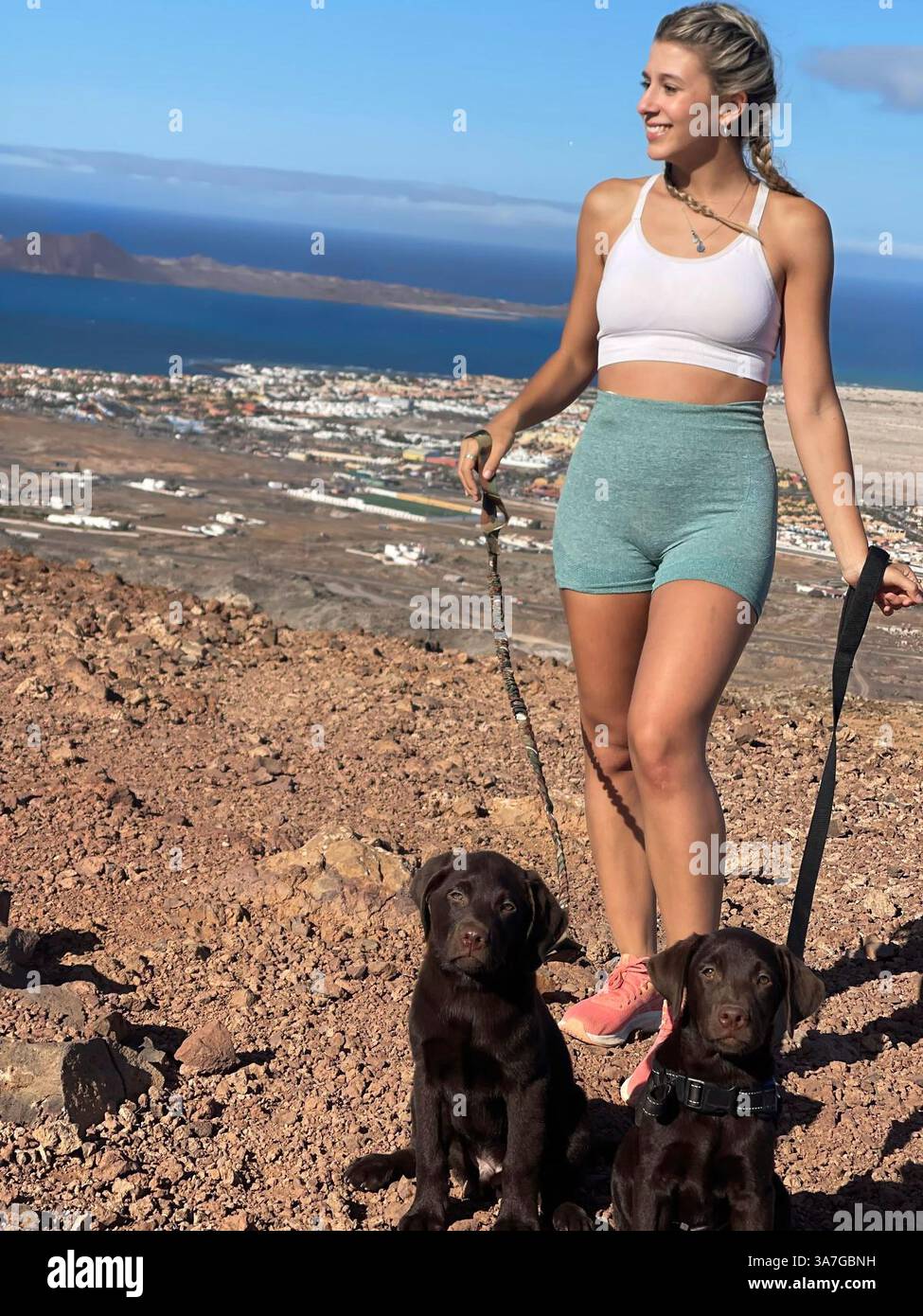Frau mit Hunden auf einem Berggipfel. Stockfoto