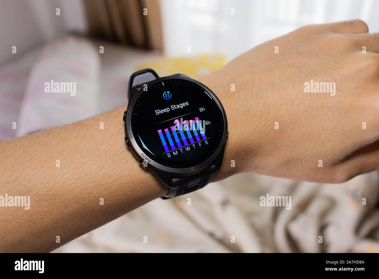 Smartwatch wird als Schlaf-Tracker mit Bett im Hintergrund verwendet. Nach Bearbeitungen. Stockfoto