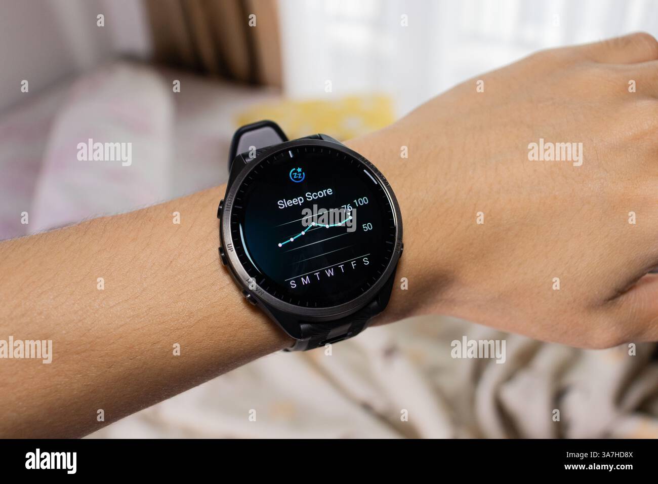 Smartwatch wird als Schlaf-Tracker mit Bett im Hintergrund verwendet. Nach Bearbeitungen. Stockfoto