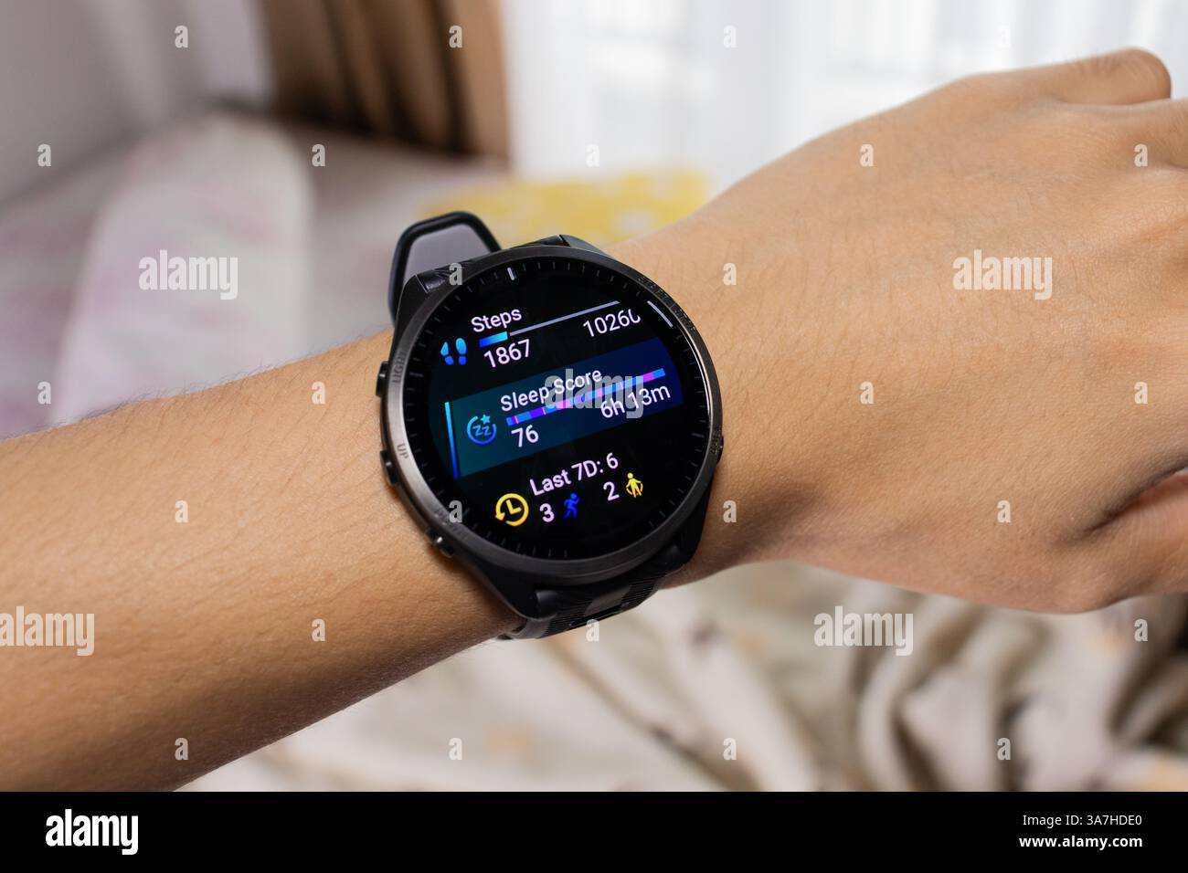 Smartwatch wird als Schlaf-Tracker mit Bett im Hintergrund verwendet. Nach Bearbeitungen. Stockfoto