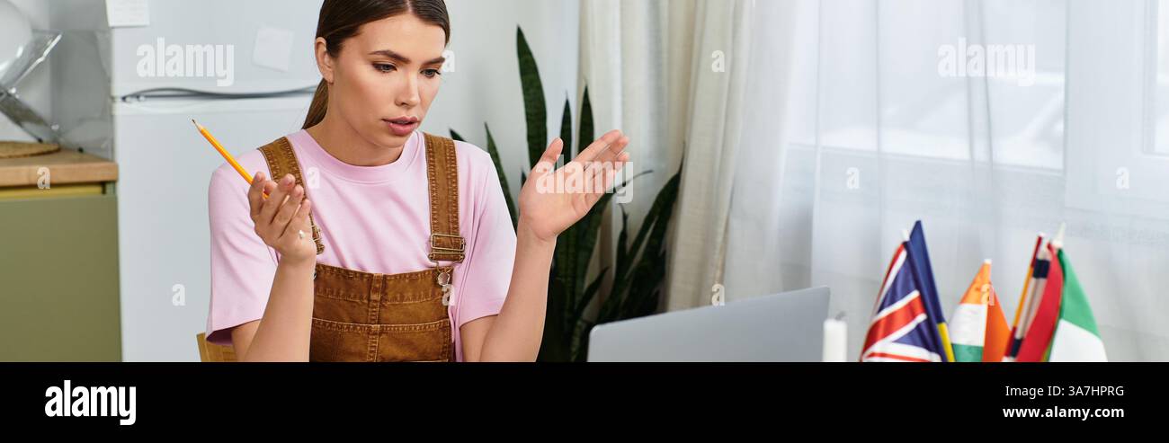Eine junge Frau übt ihre Sprachkenntnisse auf ihrem Laptop in einem gemütlichen, modernen Raum freudig aus. Stockfoto