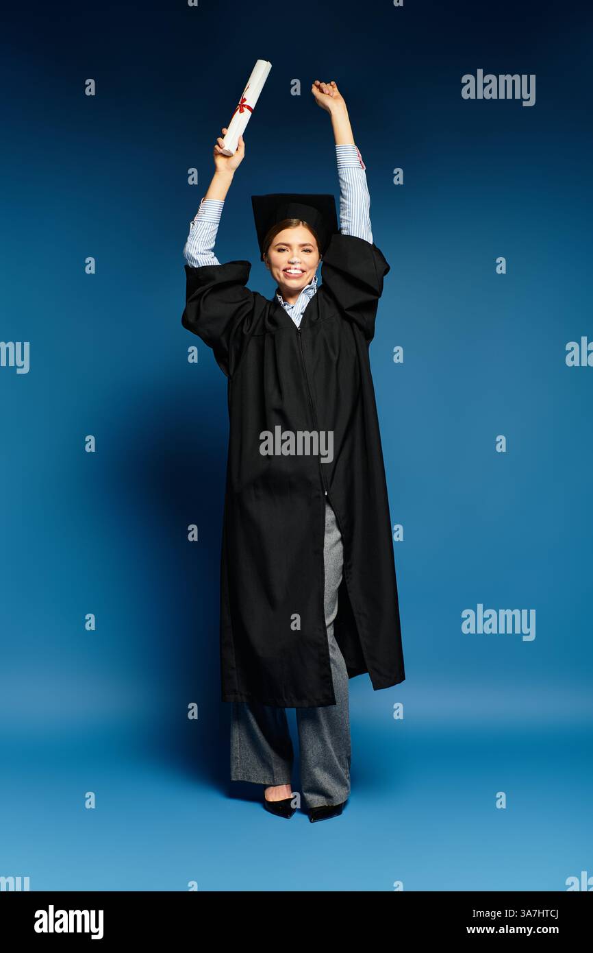 Die junge Frau hält stolz ihr Diplom und strahlt Glück und Selbstvertrauen in einem stilvollen Outfit aus. Stockfoto
