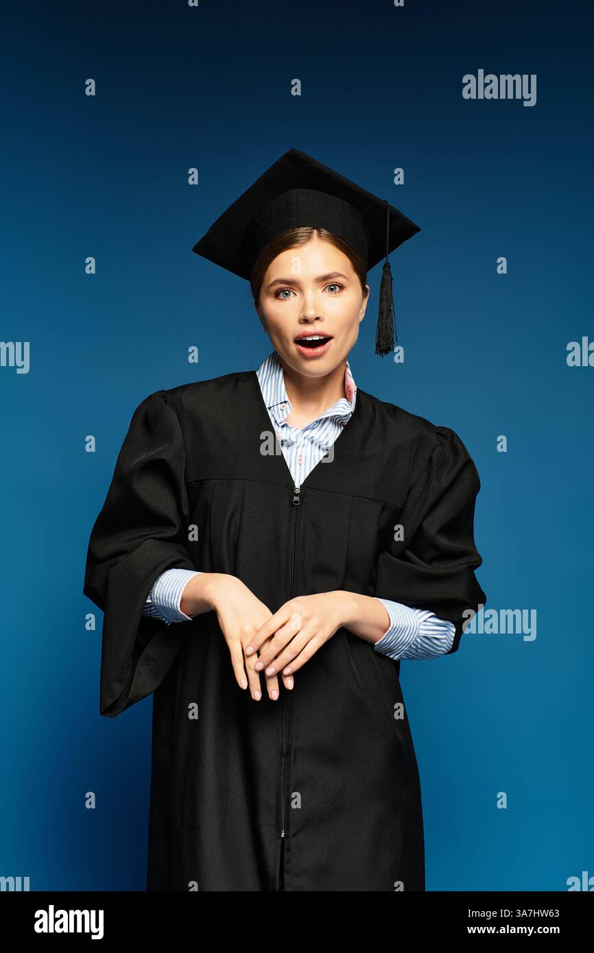 Eine junge, schöne Frau strahlt Begeisterung in ihrer Abschlusskleidung aus und feiert stolz den Erfolg. Stockfoto