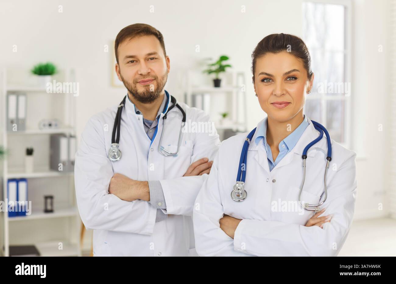 Zwei ernsthafte Ärzte, männliches und weibliches Team, Krankenschwester, die zusammen arbeiten, verschiedene Gruppen, die zusammen stehen Stockfoto