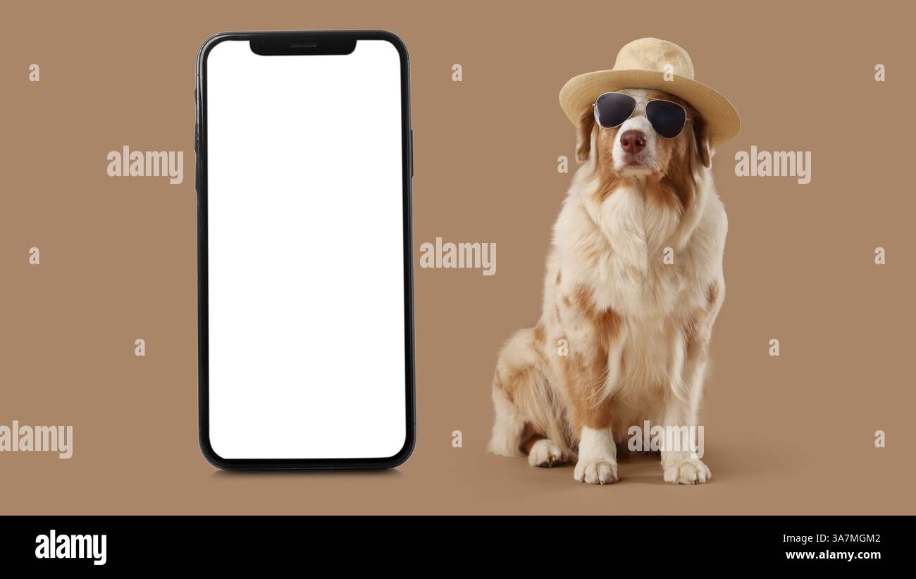 Stilvoller Hund und großes Smartphone auf beigefarbenem Hintergrund Stockfoto