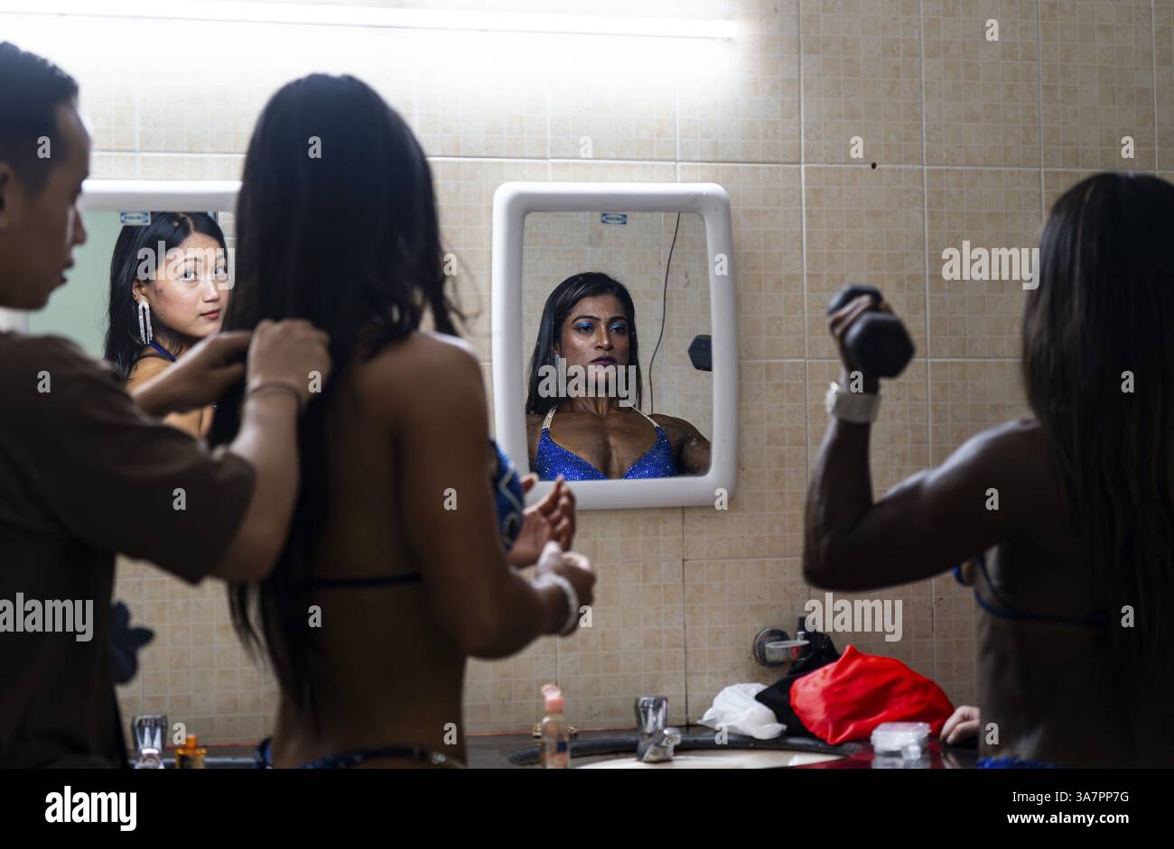 Die Teilnehmerinnen bereiten sich hinter der Bühne auf die 4. Miss Saraighat All India Classic Bodybuilding Meisterschaft am 23. März 2025 in Gu vor Stockfoto