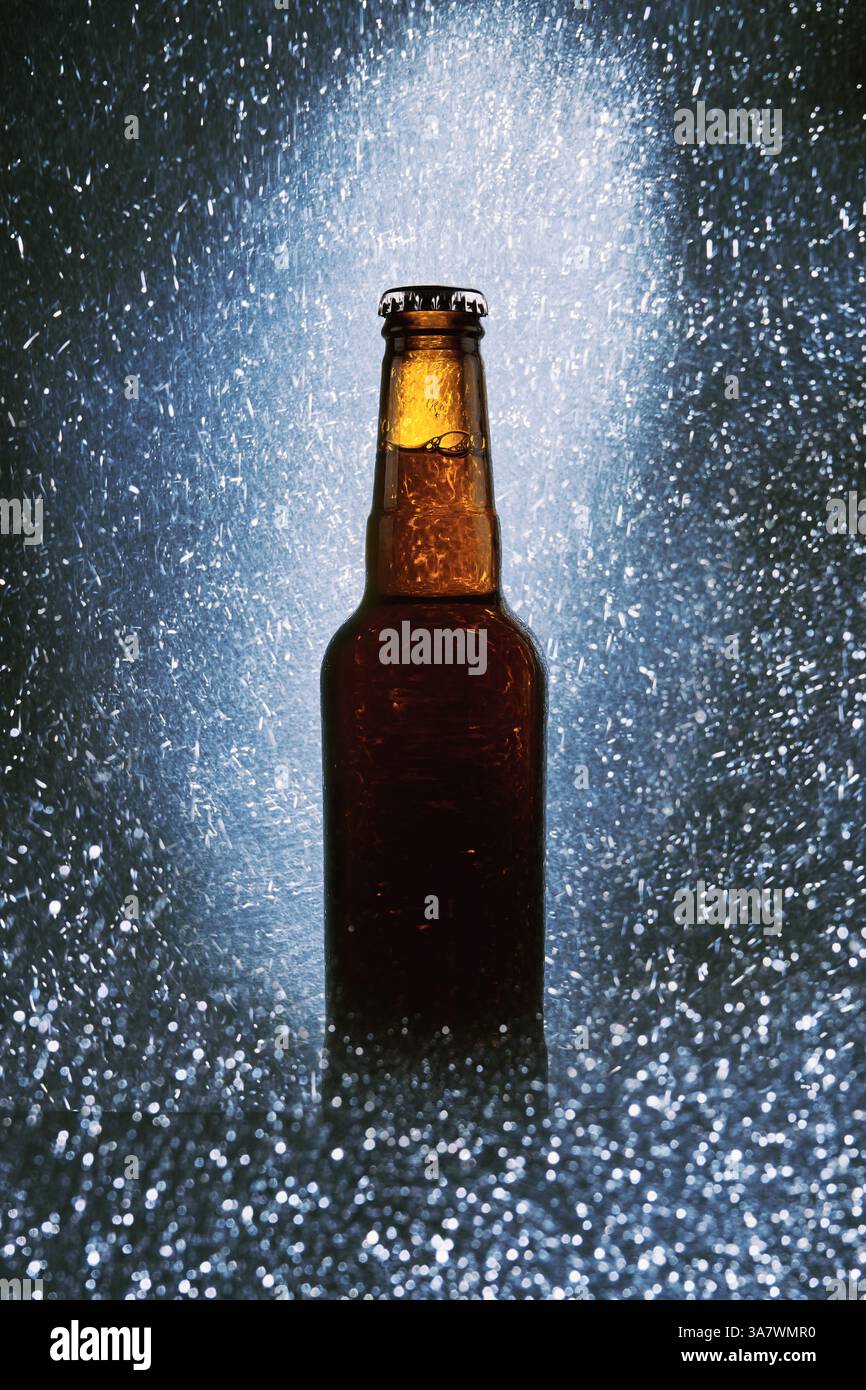 Glasflasche kaltes dunkles Bier, umgeben von funkelnden Lichtern Auf schwarzem Hintergrund Stockfoto