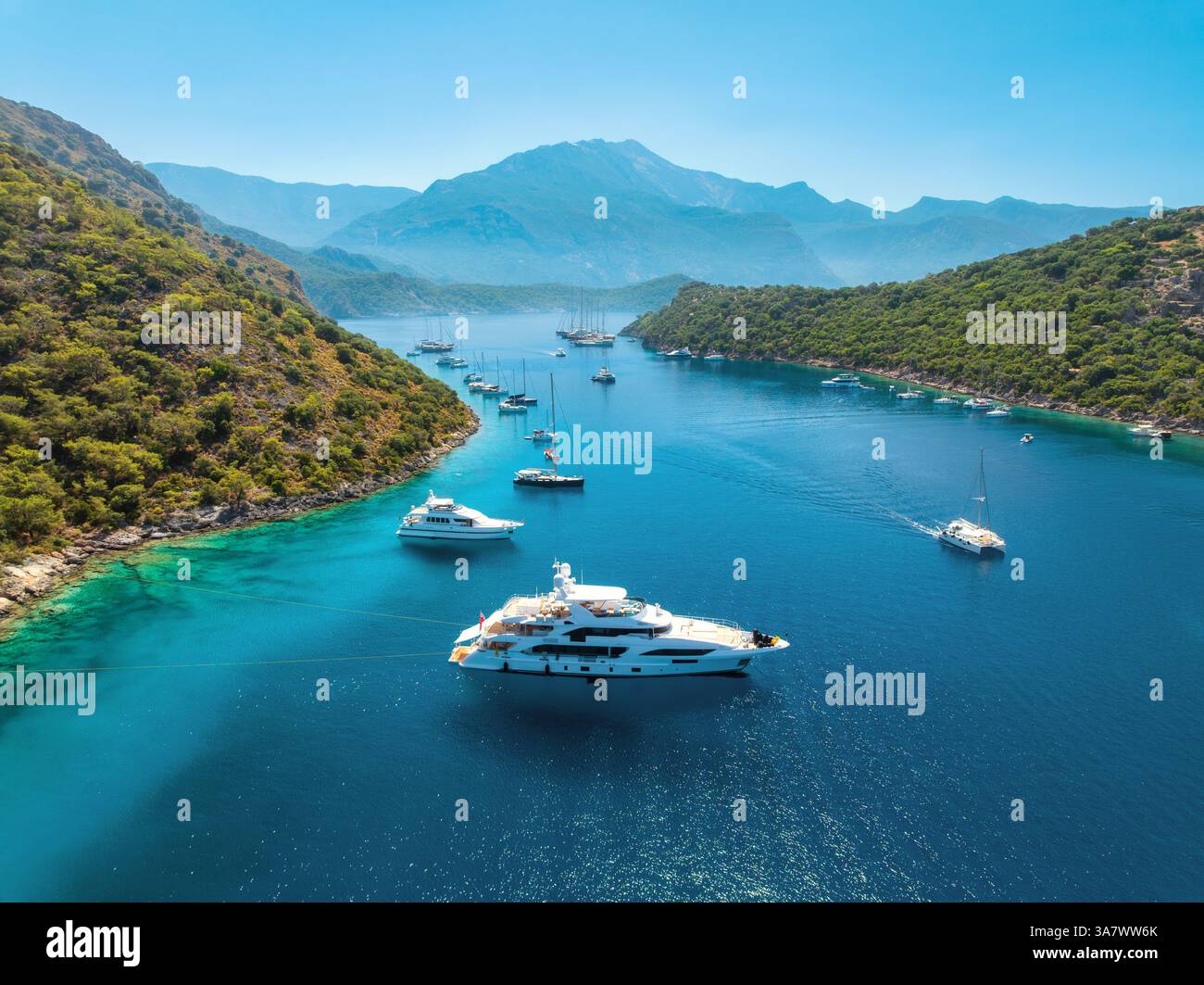 Blick aus der Vogelperspektive auf wunderschöne Yachten und Boote auf dem Meer bei Sonnenuntergang im Sommer. Gemiler Island in der Türkei. Blick von oben auf Luxusyachten, Segelboote, klares Blau mit Stockfoto