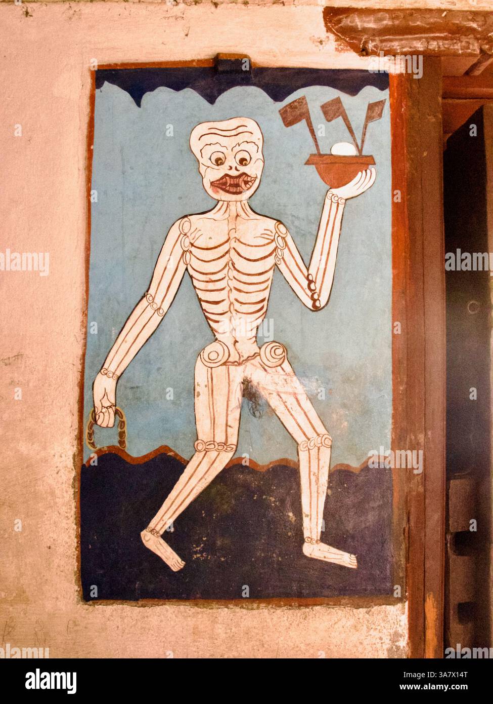 Wandbild einer Skelettfigur mit rituellen Objekten in einem Newar Patan Tempel, die Vergänglichkeit und Opfergabe in der buddhistischen Ikonographie des Himalaya symbolisieren. Stockfoto