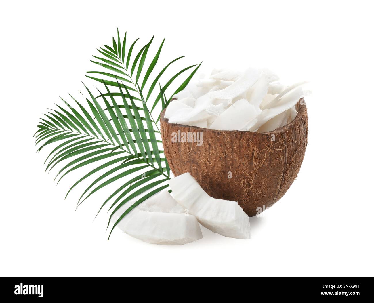 Kokosnussstücke und grüne Palmblätter isoliert auf weiß Stockfoto