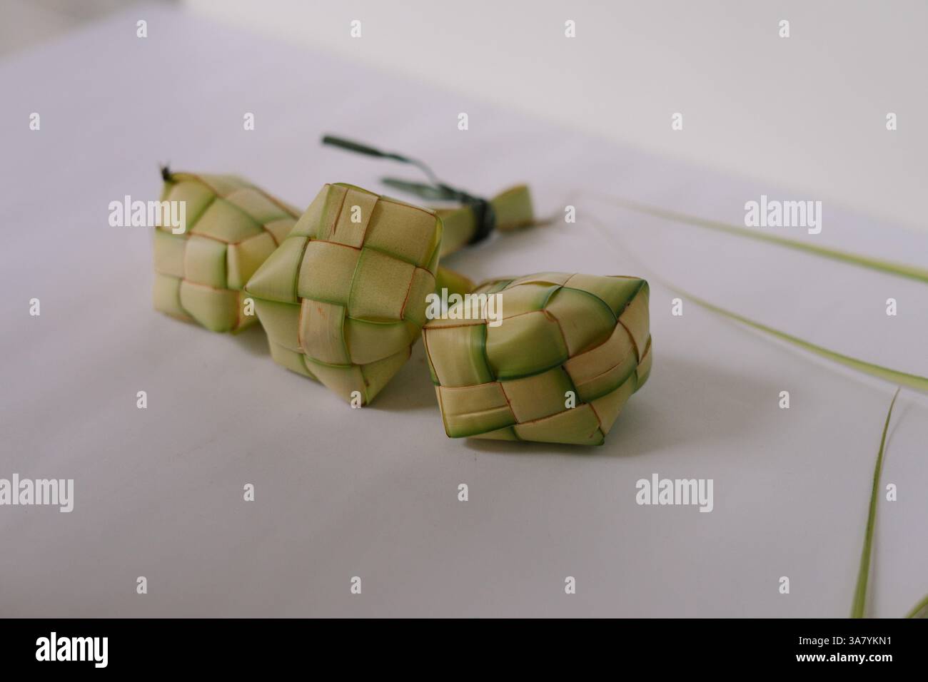 Nahaufnahme traditioneller Ketupat-Beutel, ein südostasiatisches Reisgericht aus Reis, der in gewebten Palmblättern verpackt ist. Es wird oft während der fes serviert Stockfoto