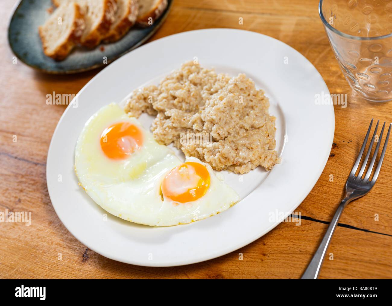 Frühstück mit Rührei und Haferbrei mit Butter aus der Nähe Stockfoto