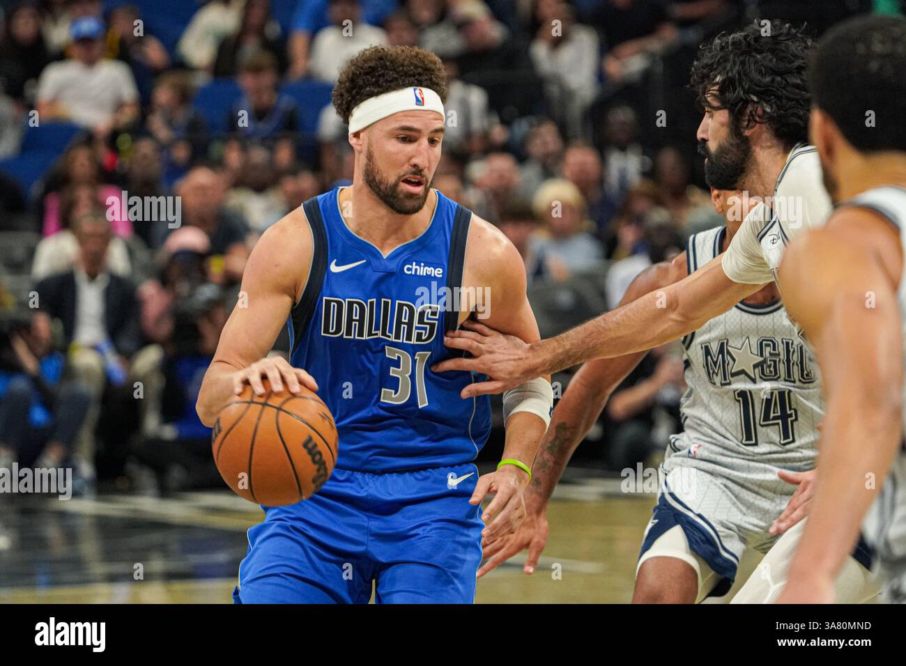 Orlando, Florida, USA, 27. März 2025, der Dallas Mavericks Wächter Klay Thompson #31 stürzt am Kia Center vorbei an Gary Harris #14. (Foto: Marty Jean-Louis/Alamy Live News Stockfoto