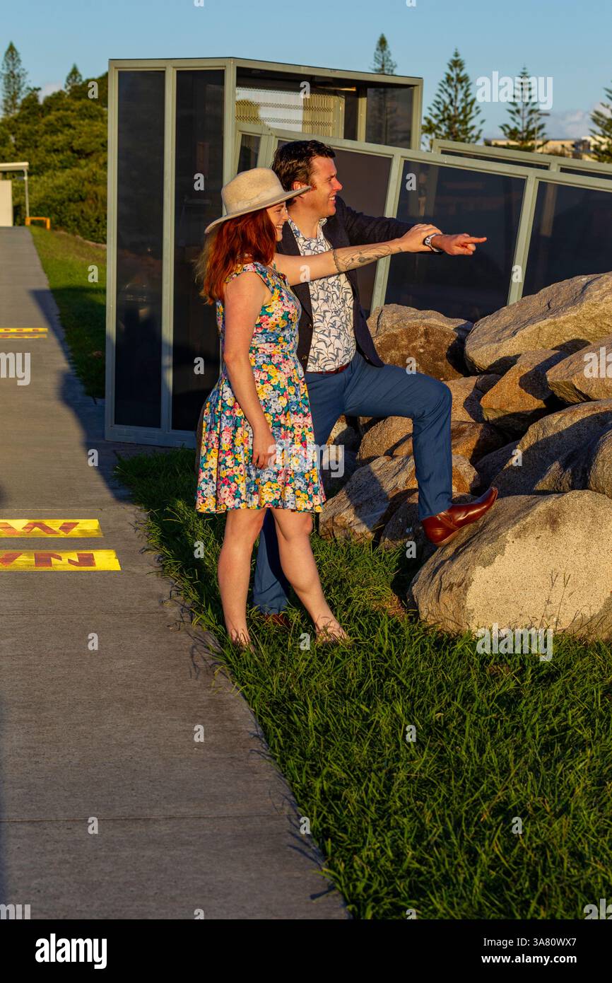 Ein Mann und eine Frau in stilvoller Kleidung beobachten die Umgebung draußen und genießen die malerische Umgebung im Freien unter hellem Sonnenlicht Stockfoto