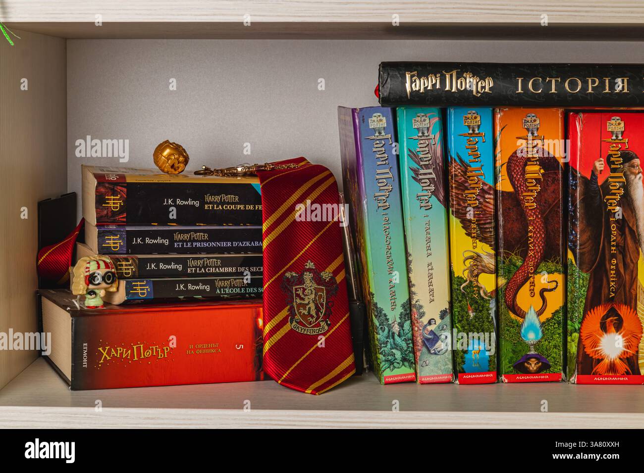 25.03.25 Lemberg Ukraine Eine kuratierte Sammlung zeigt Harry Potter Bücher in verschiedenen Sprachen zusammen mit Accessoires wie Hogwarts Krawatte, Medaillon und t Stockfoto
