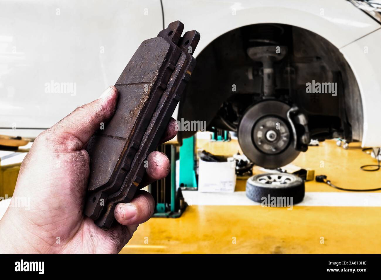 Nahaufnahme von gebrauchten Bremsbelägen in einer Kfz-Werkstatt , Prüfung von Kfz-Bremsbelägen , Konzept der Kfz-Wartung Stockfoto