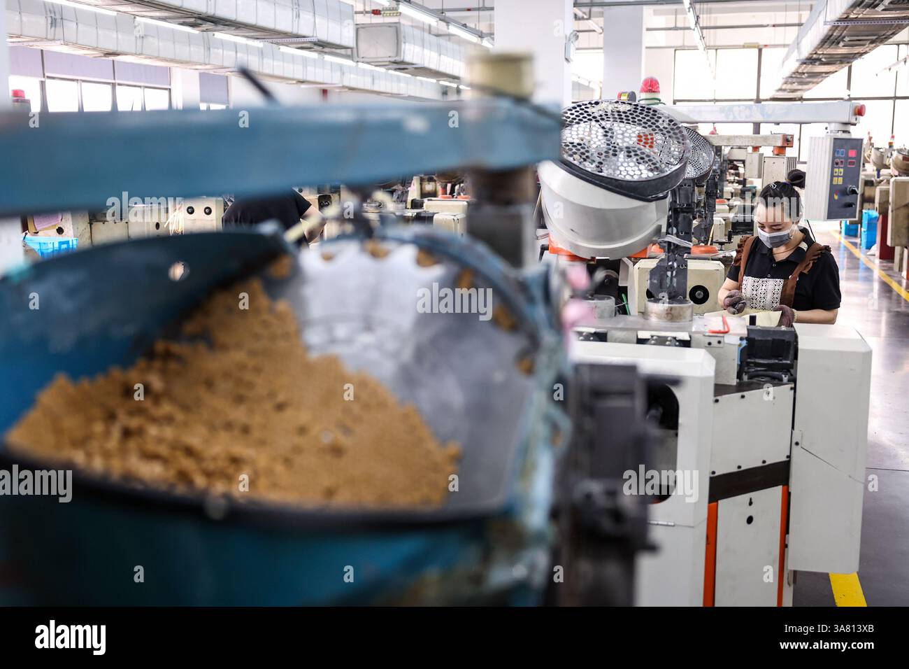 Wenzhou, chinesische Provinz Zhejiang. März 2025. Ein Mitarbeiter arbeitet in einer Werkstatt eines Bekleidungsunternehmens in der Stadt Qiaotou im Kreis Yongjia, Stadt Wenzhou, ostchinesische Provinz Zhejiang, 27. März 2025. Die Stadt Qiaotou im Yongjia County entwickelt seit Ende der 1970er Jahre ihre Button-Industrie weiter und ist mittlerweile zu einer renommierten „Button Capital“ geworden. Derzeit bieten über 250 Knopfunternehmen im Bezirk Qiaotou Arbeitsplätze für etwa 16.000 Menschen und produzieren rund 60 Milliarden Buttons mit einem Jahresumsatz von über 4 Milliarden Yuan (etwa 550,6 Millionen US-Dollar). Quelle: Jiang Han/Xinhua/Alamy Live News Stockfoto