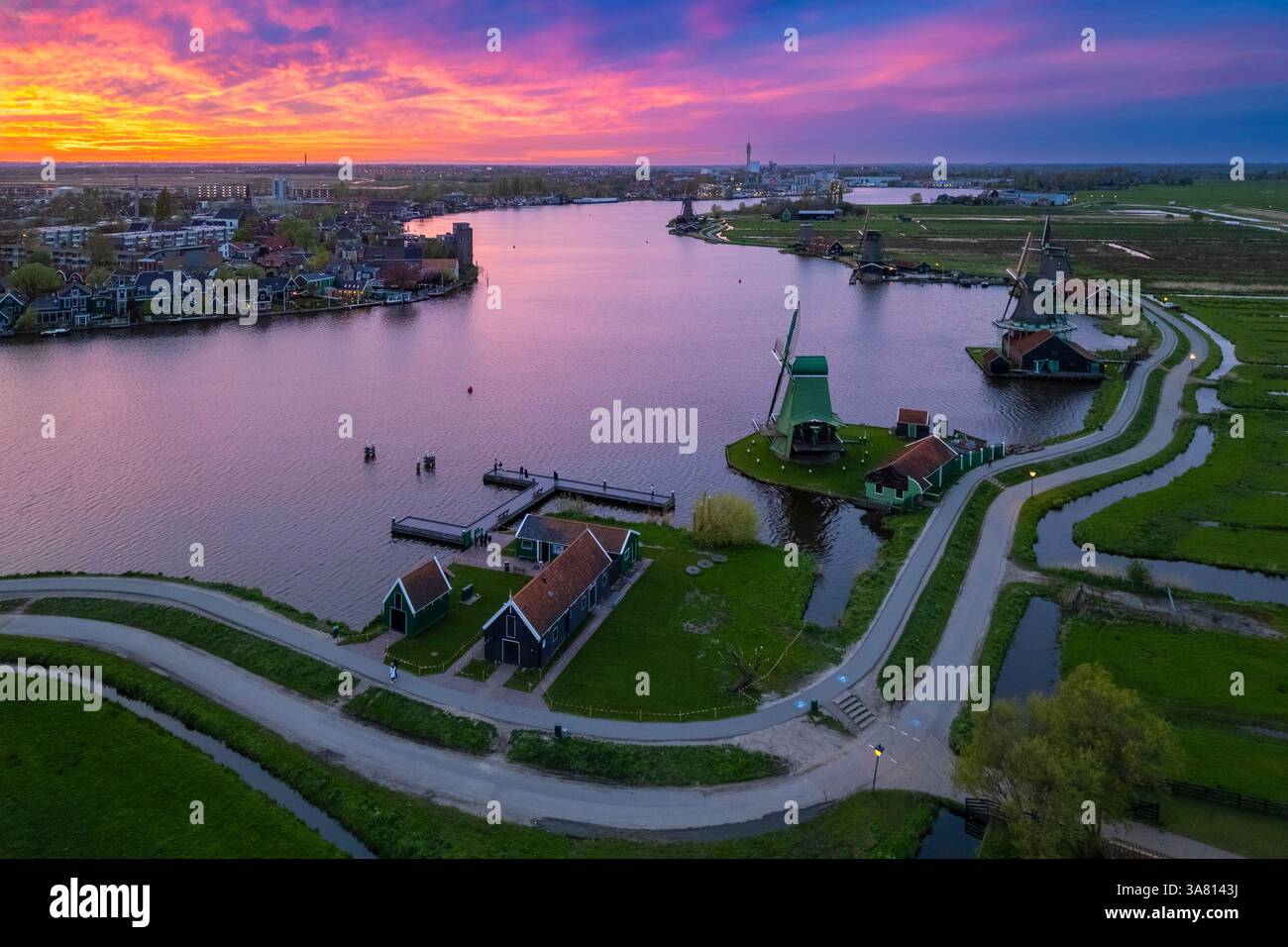 Luftaufnahme der typischen Windmühlen von Zaanse Schans auf dem Fluss Zaan im Frühling. Zaanse Schans, Nordholland, Gemeinde Zaanstad, Niederlande Stockfoto