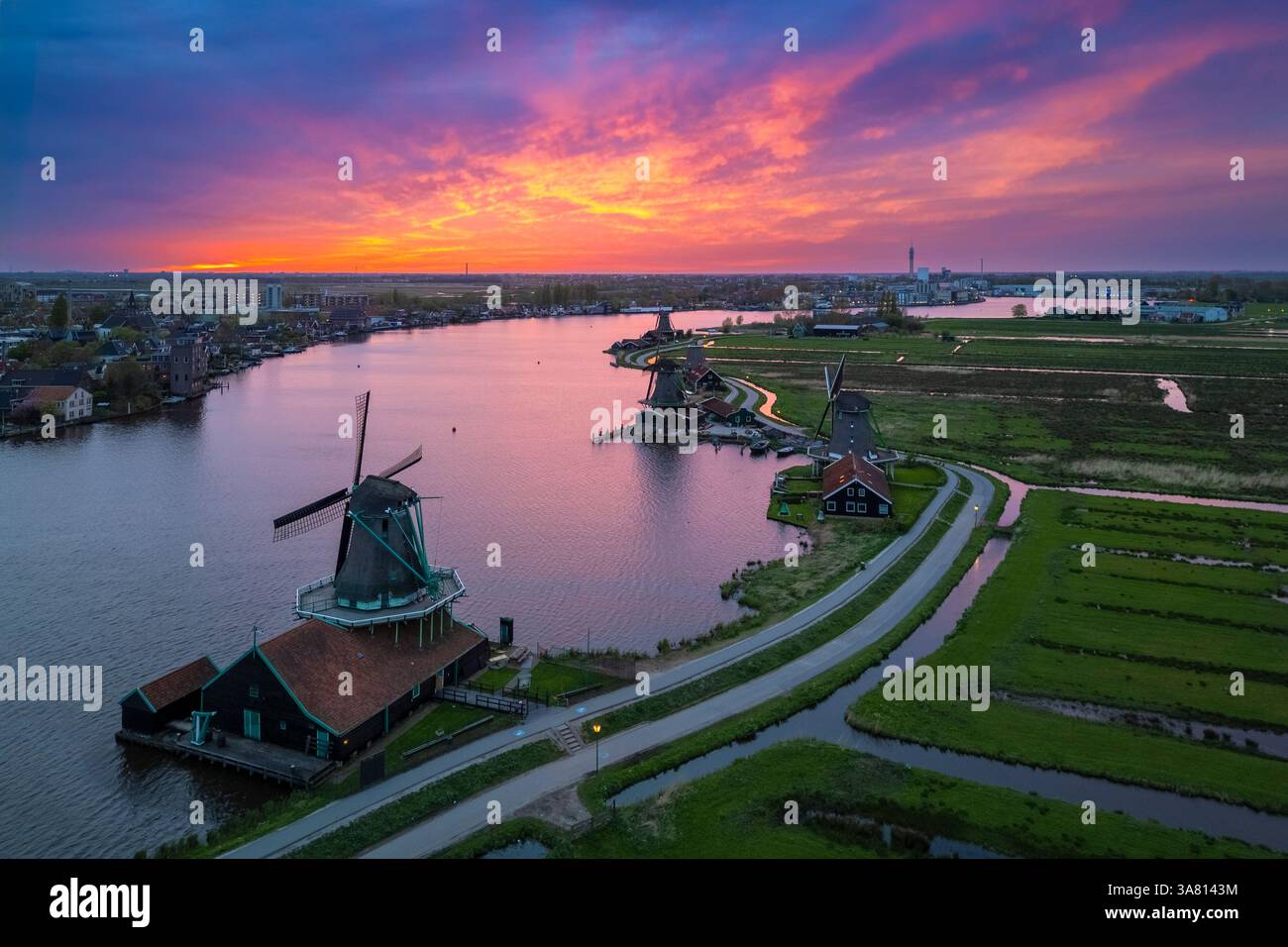 Luftaufnahme der typischen Windmühlen von Zaanse Schans auf dem Fluss Zaan im Frühling. Zaanse Schans, Nordholland, Gemeinde Zaanstad, Niederlande Stockfoto