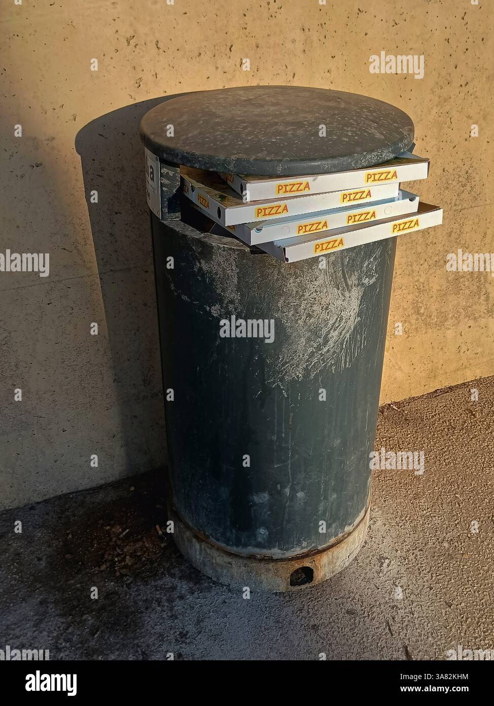 Leere Pizzakartons in einem öffentlichen Mülleimer auf der Straße Stockfoto