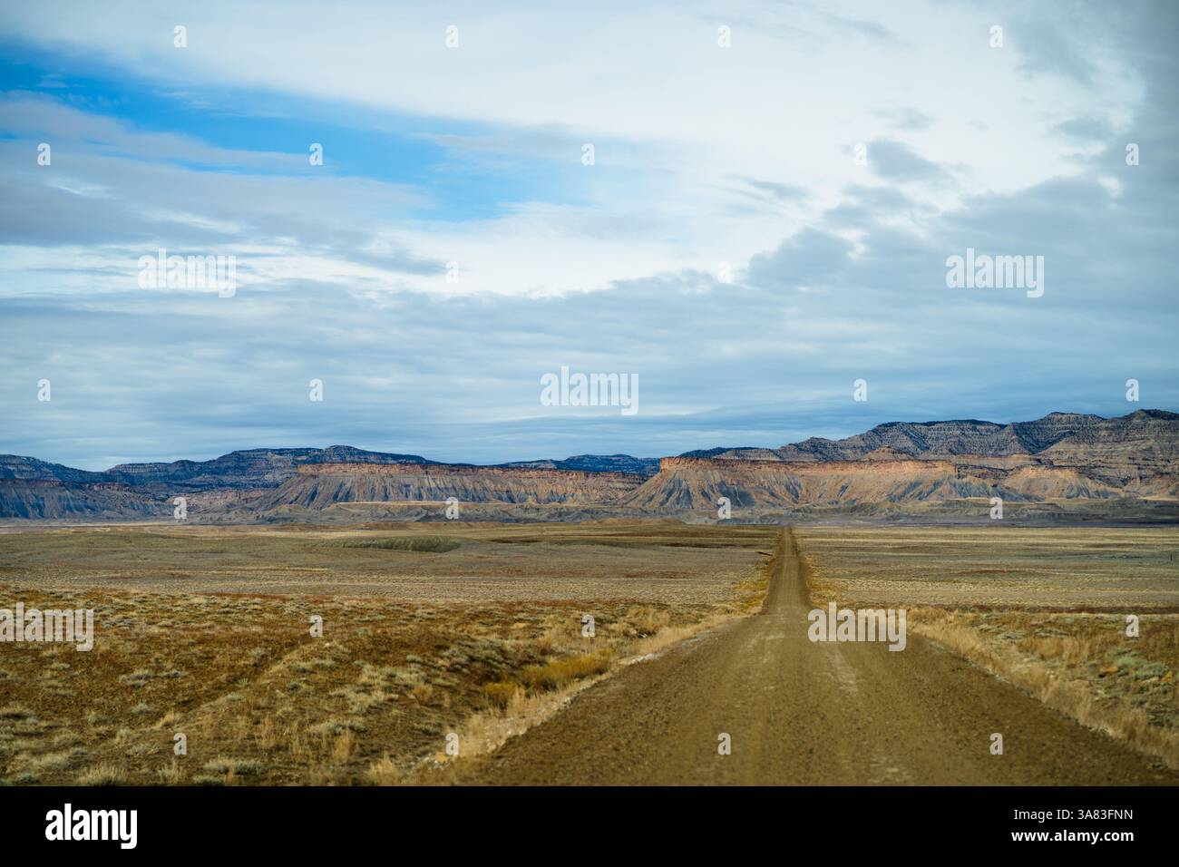 Eine endlose unbefestigte Straße führt zu den zerklüfteten Badlands von Utah, fram Stockfoto