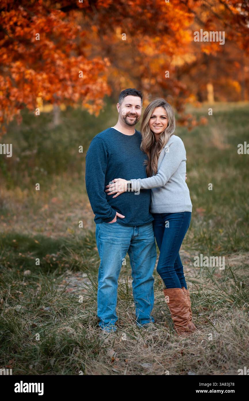 Ehemann und Frau stehen zusammen und lächeln in einem schönen Herbstfeld Stockfoto