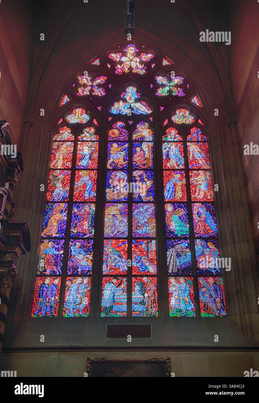 PRAG - 11. MAI 2024: Sonnenlicht beleuchtet bunte Buntglasfenster, die religiöse Szenen in der gotischen Kathedrale St. Veit in Prag darstellen Stockfoto PRAG - 11. MAI 2024: Sonnenlicht beleuchtet bunte Buntglasfenster, die religiöse Szenen in der gotischen Kathedrale St. Veit in Prag darstellen Stockfoto