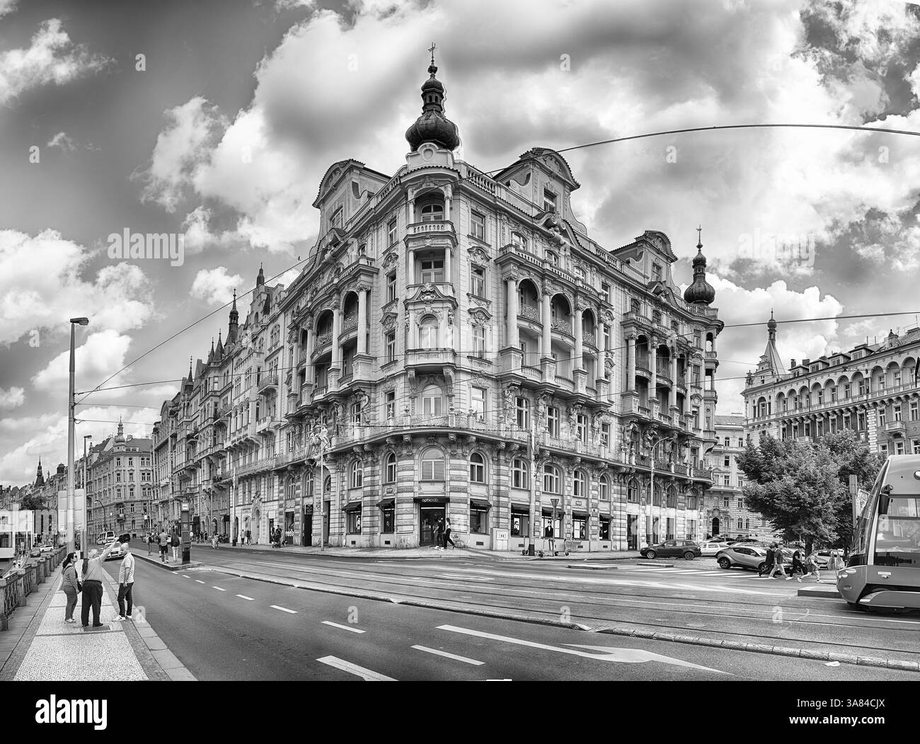 PRAG - 12. MAI 2024: Touristen genießen einen sonnigen Tag in Prag, Tschechische Republik, zu Fuß auf einer belebten Straße mit historischen Gebäuden und einer Straßenbahn Stockfoto PRAG - 12. MAI 2024: Touristen genießen einen sonnigen Tag in Prag, Tschechische Republik, zu Fuß auf einer belebten Straße mit historischen Gebäuden und einer Straßenbahn Stockfoto