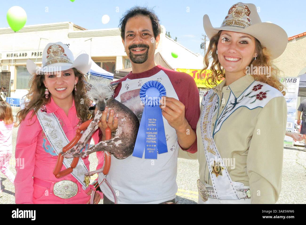März 30, 2013 - Highland, Kalifornien, USA - flankiert von Jr. Miss & Rodeo Queen of the San Bernadino County Sheriff's Rodeo, SABRINA SNOWBALL & CAITLIN EBERHARDT, Besitzer DANE ANDREW und SCHURKE ein 6,5 kg schwer haarloses Tier, das manchmal Chupacabra genannt wird, wurde zum 5. Jahr in Folge beim Southern California Hässly Dog Contest ungeschlagen, wie durch öffentliche Abstimmung während des Citrus Harvest Festival der Stadt festgelegt. Rascal hat mehr hässliche Hunde-Titel gewonnen als jeder andere Hund in der Geschichte und ist nun auf dem Weg zu den Seiten der Guinness-Weltrekorde. Alle Gewinne wurden an „Hope to Home“ für Cats und San B gespendet Stockfoto