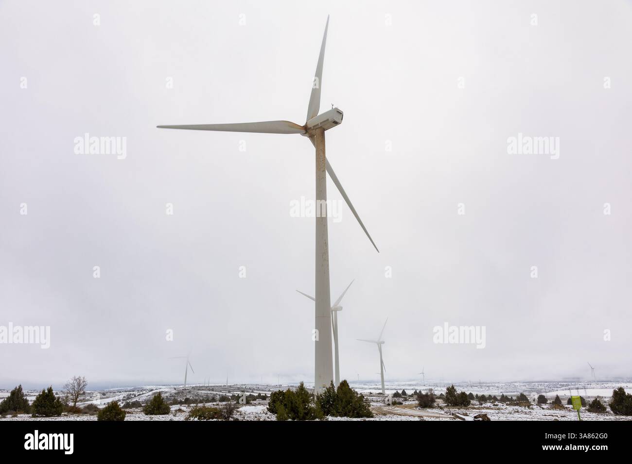 Windkraftanlage mit Schnee und Nebel Stockfoto