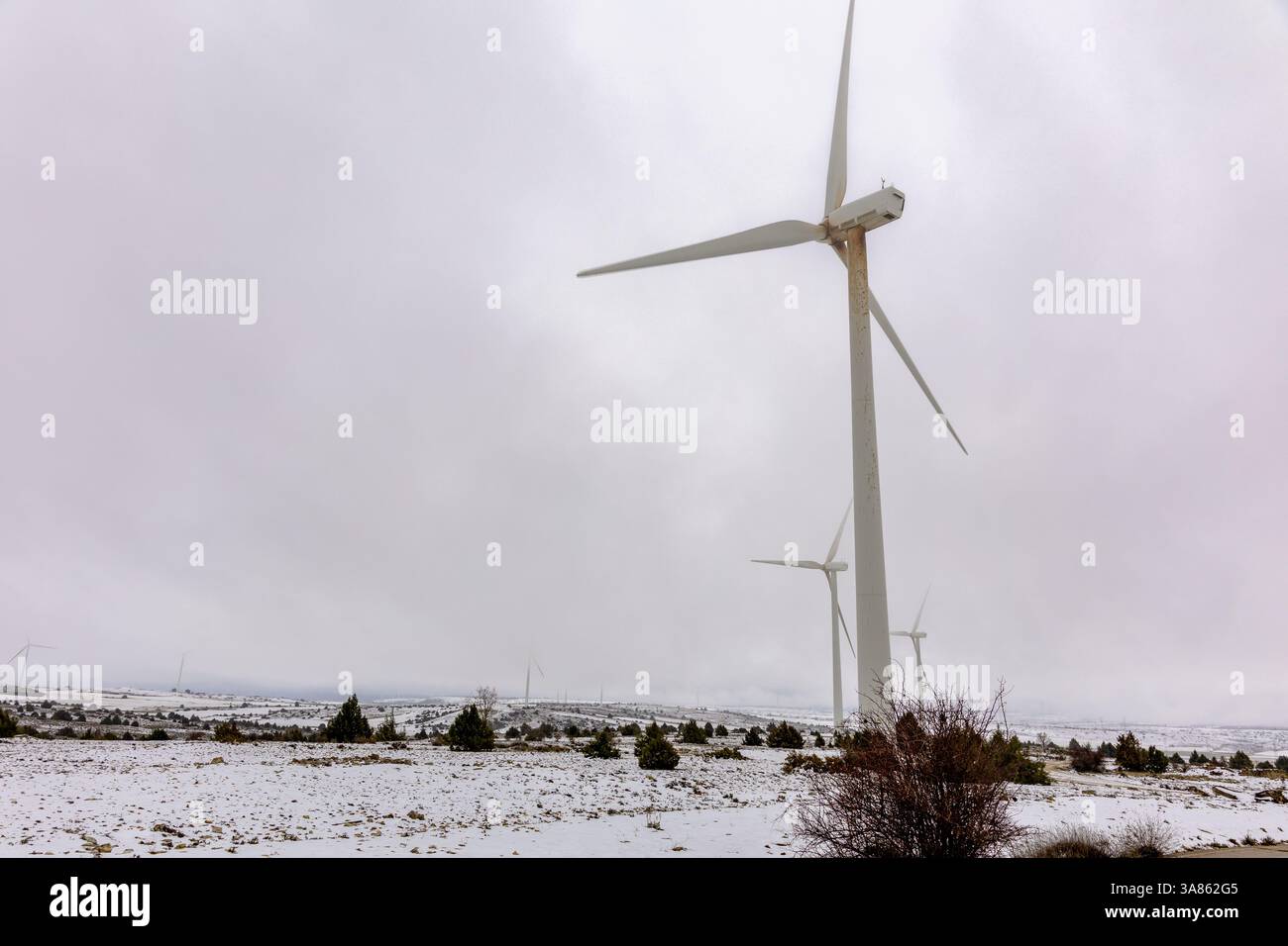 Windkraftanlage mit Schnee und Nebel Stockfoto