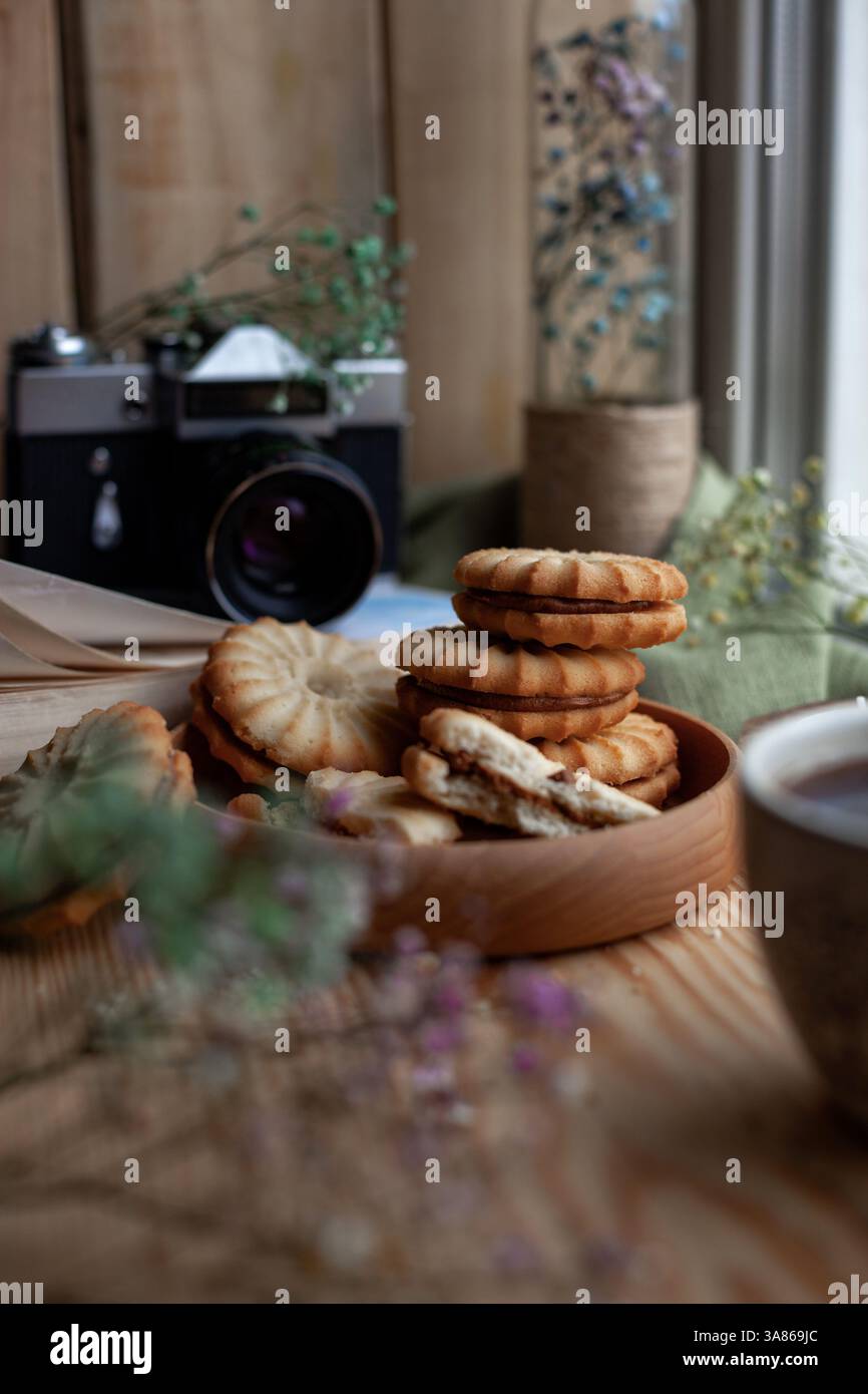 Ein Stapel hausgemachter Kuchen mit Kondensmilch auf hölzernem Hintergrund, Hausbäckerei Stockfoto