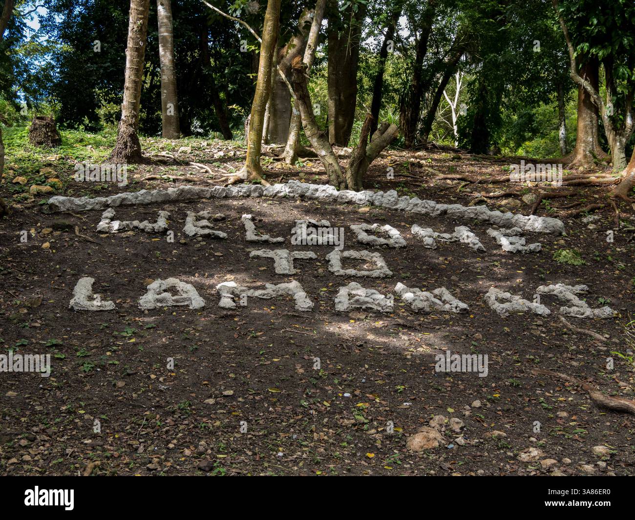 Begrüßungsschild an der mesoamerikanischen archäologischen Stätte Lamanai (untergetauchtes Krokodil), Belize Stockfoto