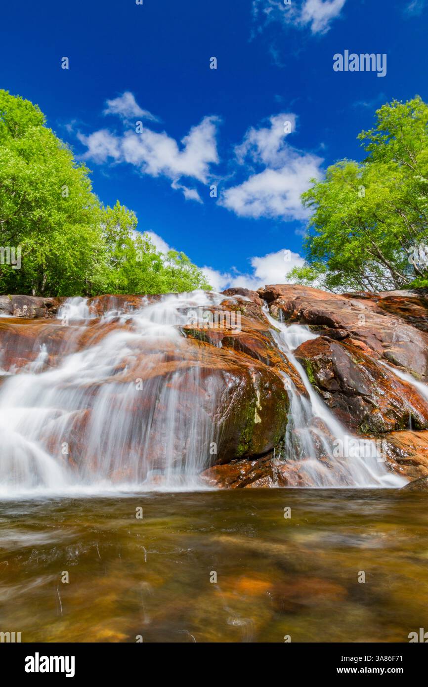 Ein wunderschöner Wasserfall außerhalb des kleinen norwegischen Sommergebietes in der Sandvika Bay auf der Südseite von Svesfjord, Norwegen Stockfoto