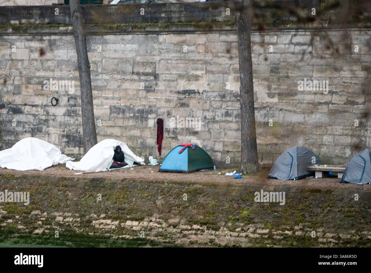 Paris, Frankreich. März 2025. Ein provisorisches Migrantenlager hat sich entlang der seine in Paris nach der Vertreibung der Bewohner aus dem Theater Gaîté Lyrique gebildet. Am 28. März 2025, in den frühen Morgenstunden, erließ die Pariser Polizeipräfektur einen förmlichen Evakuierungsbefehl für das Gelände. Die Operation steht noch aus, als Reaktion auf eine Berufung humanitärer Organisationen ein Gerichtsurteil ergangen ist. Paris, Frankreich am 28. März 2025. Foto: Florian Poitout/ABACAPRESS. COM Credit: Abaca Press/Alamy Live News Stockfoto