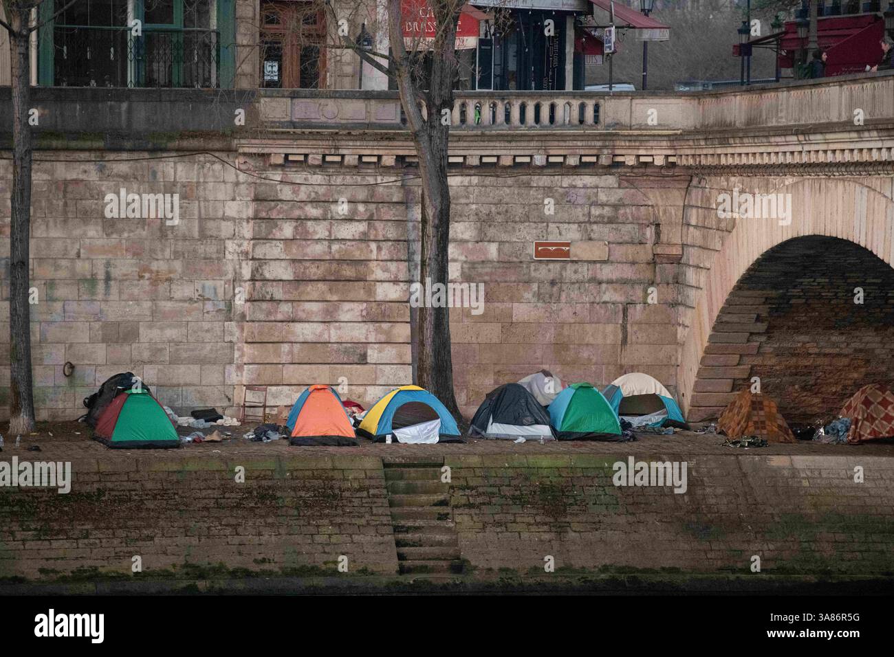 Paris, Frankreich. März 2025. Ein provisorisches Migrantenlager hat sich entlang der seine in Paris nach der Vertreibung der Bewohner aus dem Theater Gaîté Lyrique gebildet. Am 28. März 2025, in den frühen Morgenstunden, erließ die Pariser Polizeipräfektur einen förmlichen Evakuierungsbefehl für das Gelände. Die Operation steht noch aus, als Reaktion auf eine Berufung humanitärer Organisationen ein Gerichtsurteil ergangen ist. Paris, Frankreich am 28. März 2025. Foto: Florian Poitout/ABACAPRESS. COM Credit: Abaca Press/Alamy Live News Stockfoto