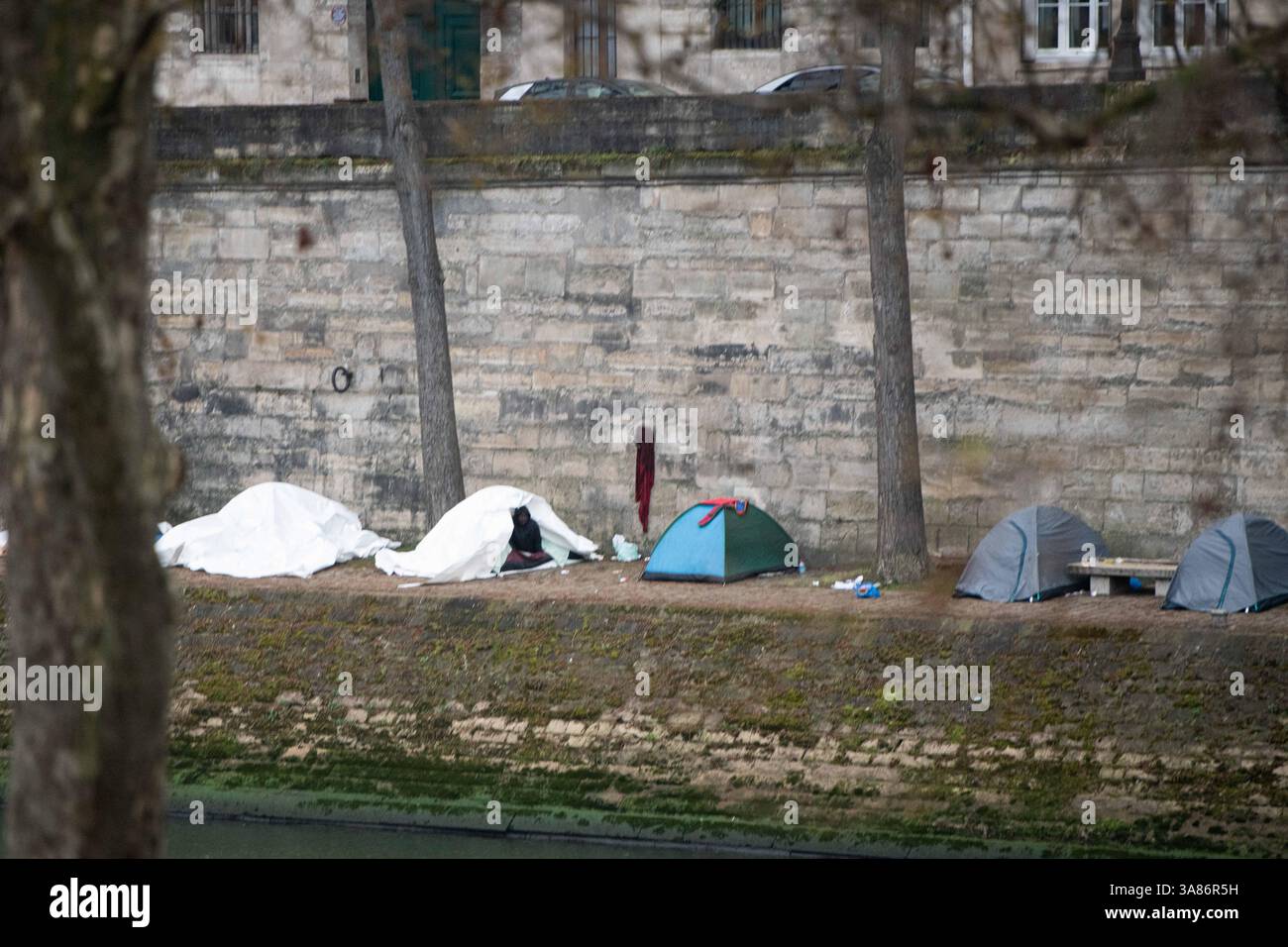 Paris, Frankreich. März 2025. Ein provisorisches Migrantenlager hat sich entlang der seine in Paris nach der Vertreibung der Bewohner aus dem Theater Gaîté Lyrique gebildet. Am 28. März 2025, in den frühen Morgenstunden, erließ die Pariser Polizeipräfektur einen förmlichen Evakuierungsbefehl für das Gelände. Die Operation steht noch aus, als Reaktion auf eine Berufung humanitärer Organisationen ein Gerichtsurteil ergangen ist. Paris, Frankreich am 28. März 2025. Foto: Florian Poitout/ABACAPRESS. COM Credit: Abaca Press/Alamy Live News Stockfoto