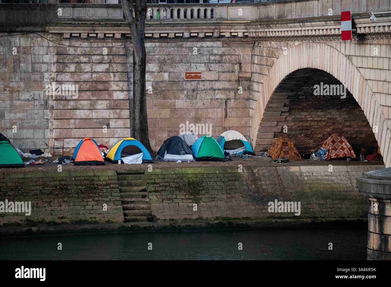 Paris, Frankreich. März 2025. Ein provisorisches Migrantenlager hat sich entlang der seine in Paris nach der Vertreibung der Bewohner aus dem Theater Gaîté Lyrique gebildet. Am 28. März 2025, in den frühen Morgenstunden, erließ die Pariser Polizeipräfektur einen förmlichen Evakuierungsbefehl für das Gelände. Die Operation steht noch aus, als Reaktion auf eine Berufung humanitärer Organisationen ein Gerichtsurteil ergangen ist. Paris, Frankreich am 28. März 2025. Foto: Florian Poitout/ABACAPRESS. COM Credit: Abaca Press/Alamy Live News Stockfoto