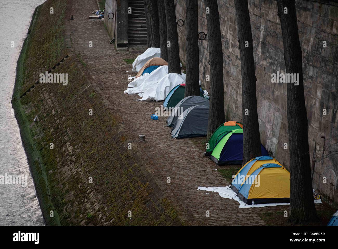 Paris, Frankreich. März 2025. Ein provisorisches Migrantenlager hat sich entlang der seine in Paris nach der Vertreibung der Bewohner aus dem Theater Gaîté Lyrique gebildet. Am 28. März 2025, in den frühen Morgenstunden, erließ die Pariser Polizeipräfektur einen förmlichen Evakuierungsbefehl für das Gelände. Die Operation steht noch aus, als Reaktion auf eine Berufung humanitärer Organisationen ein Gerichtsurteil ergangen ist. Paris, Frankreich am 28. März 2025. Foto: Florian Poitout/ABACAPRESS. COM Credit: Abaca Press/Alamy Live News Stockfoto