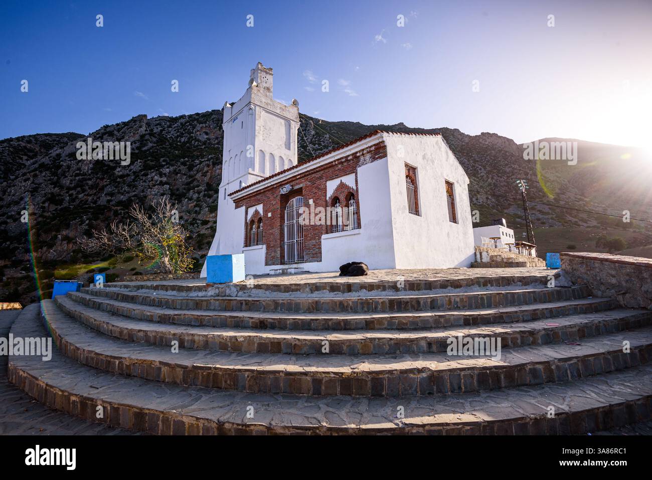 Sonnenaufgang hinter der weißen Bouzafer Moschee (spanische Moschee) und ihren Treppen auf dem Hügel, Chefchaouen, Marokko Stockfoto