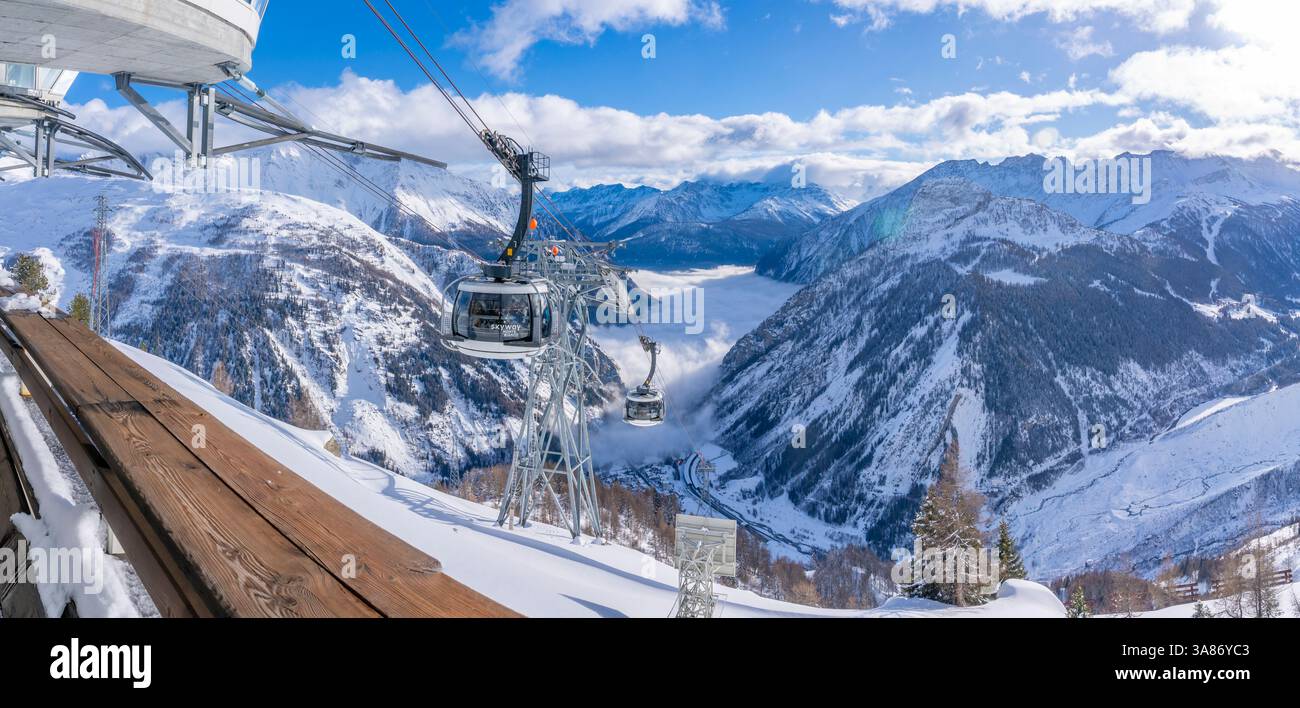 Blick auf das schneebedeckte Aostatal, die Berge und die Seilbahn „Skyway Monte Bianco“ im Winter, Courmayeur, das Aostatal, die italienischen Alpen, Italien Stockfoto