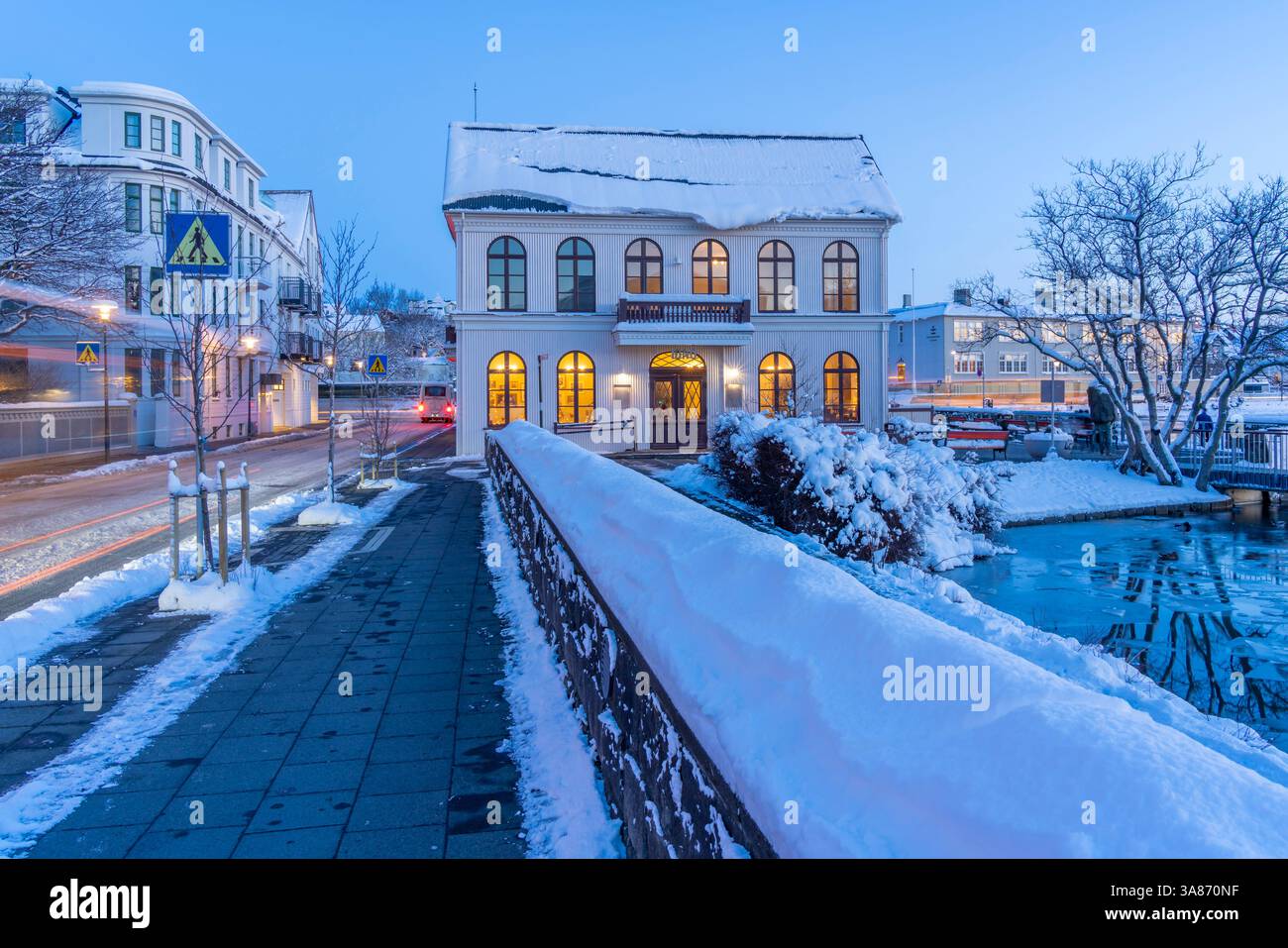 Blick auf die kunstvollen Gebäude von Reykjavik vom Tjornin See in der Abenddämmerung im Winter, Reykjavik, Island Stockfoto