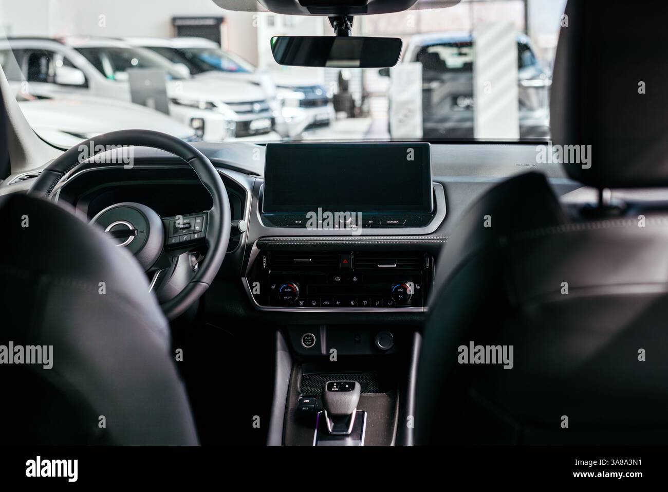 Nahaufnahme eines Autolenkrads in einem modernen Neuwagen. Der Innenraum eines stilvollen neuen Autos. Konzept für stilvolles Design, Shopping und Autoteile. Stockfoto