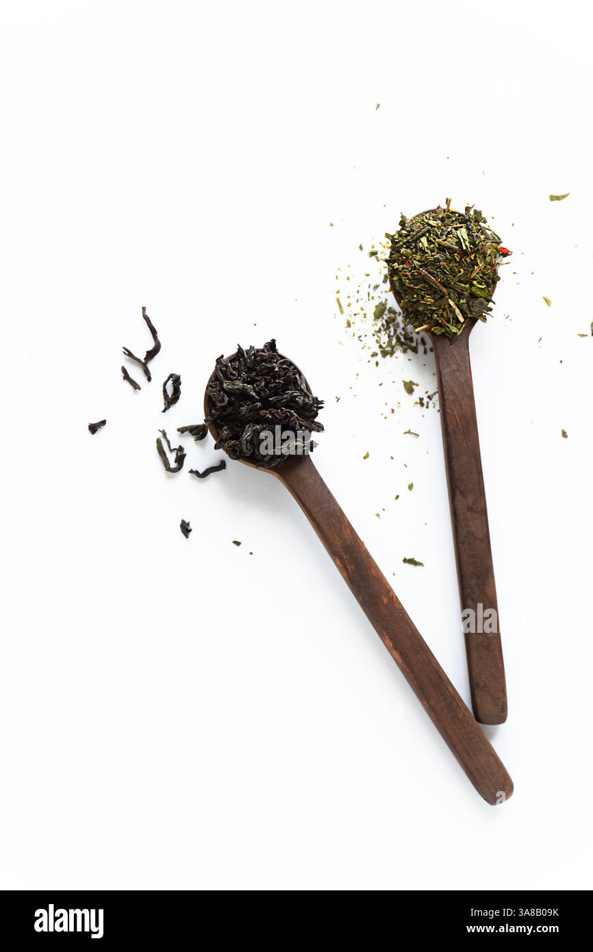 Schwarze und grüne Tees mit losen Blättern in Holzlöffeln isoliert auf weißem Hintergrund von oben Stockfoto