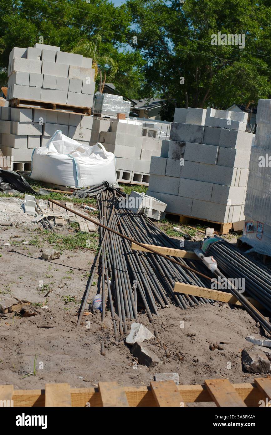 Stapel von hellgrauen, leicht strukturierten Betonblöcken, auch als Schlackenblöcke oder Betonmauerwerk (CMU) bezeichnet, auf einer Baustelle. Bewehrung in Stockfoto Stapel von hellgrauen, leicht strukturierten Betonblöcken, auch als Schlackenblöcke oder Betonmauerwerk (CMU) bezeichnet, auf einer Baustelle. Bewehrung in Stockfoto