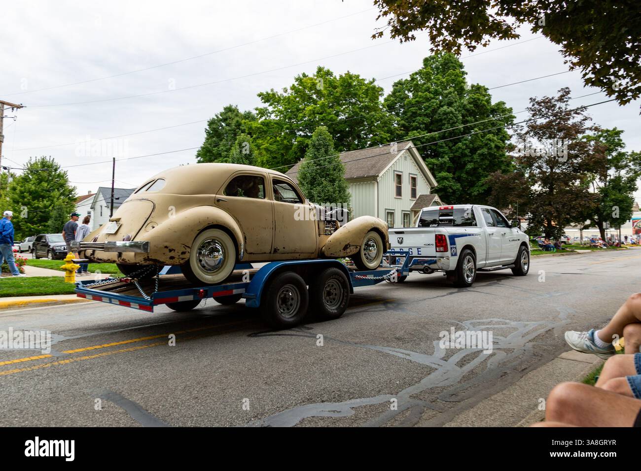 Eine gelbe Cord Westchester Limousine wird auf einem Anhänger durch die ACD Festival Parade von einem Dodge RAM Pickup Truck in Auburn, Indiana, USA gezogen. Stockfoto